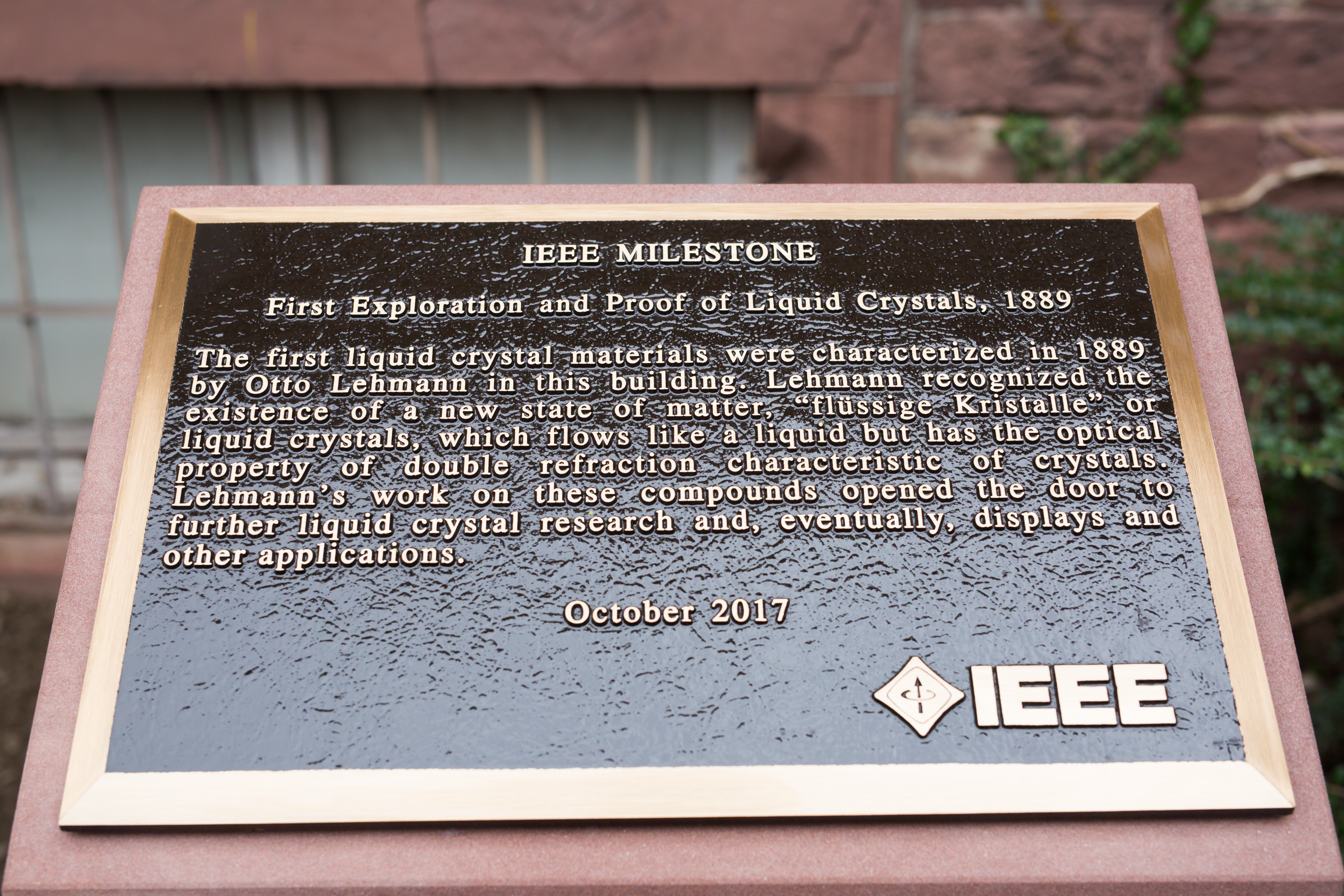 Der im Ehrenhof am Campus Süd des KIT angebrachte Milestone des Institute of Electrical and Electronics Engineers (IEEE) zur Würdigung der Flüssigkristallforschung von Otto Lehmann, Aufnahme 2017. Foto: Amadeus Bramsiepe.